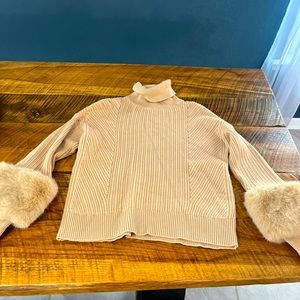small beige sweater with fur cuffed sleeves